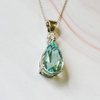 lifestyle micro shot of a aquamarine and diamond pendant 