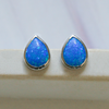 blue created opal earrings on a soap dish