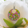 a stunning pink and green cz pendant necklace on a floral background