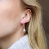 Silver drop earrings on blonde woman