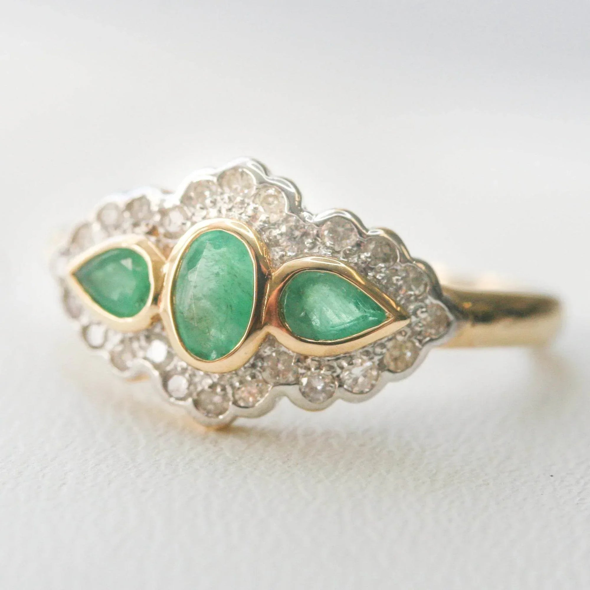 Art Deco Style Three Stone Emerald and Diamond Halo Ring - Jordans Jewellers